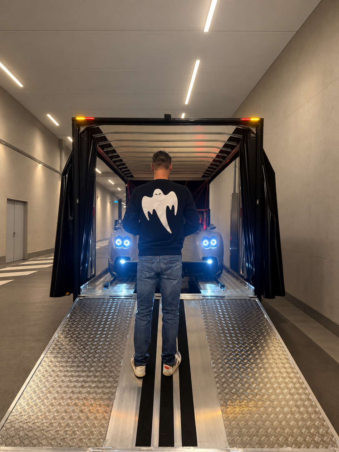 Le fondateur de Liberty Services devant une supercar chargée sur remorque